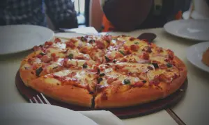 Pyszna, gorąca pizza z kurczakiem i cebulą, idealna do odgrzania. Smacznego!