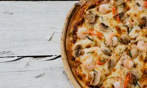 Pizza z krewetkami i pieczarkami, idealna do nauki, jak rozciągnąć ciasto na pizzę.