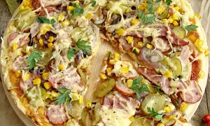Pizza wiejska składniki: ser, kukurydza, ogórek kiszony, cebula, kiełbasa, szynka, natka pietruszki. Apetyczny widok!