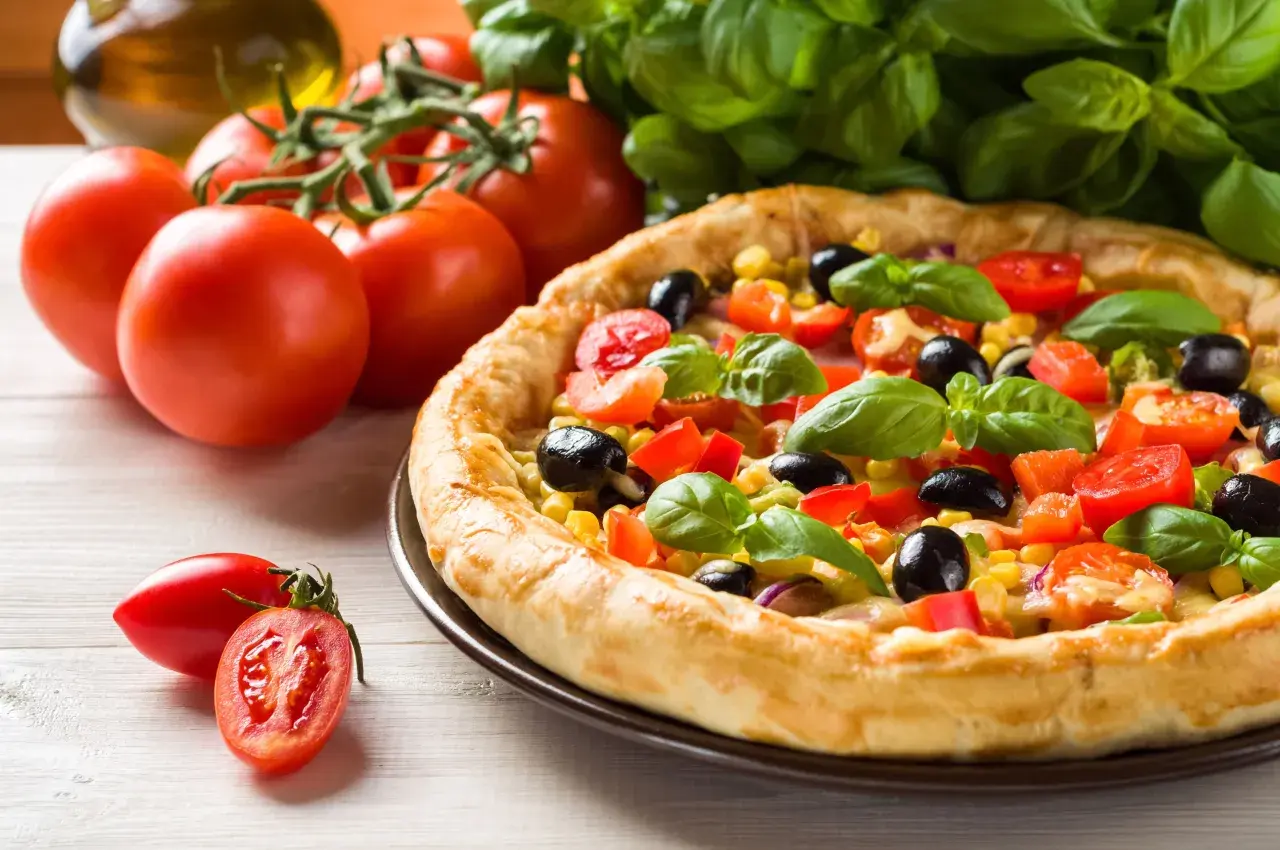 Pyszna pizza z pomidorami, oliwkami i kukurydzą. Idealna na szybki obiad, a czas pieczenia to klucz do jej doskonałości.