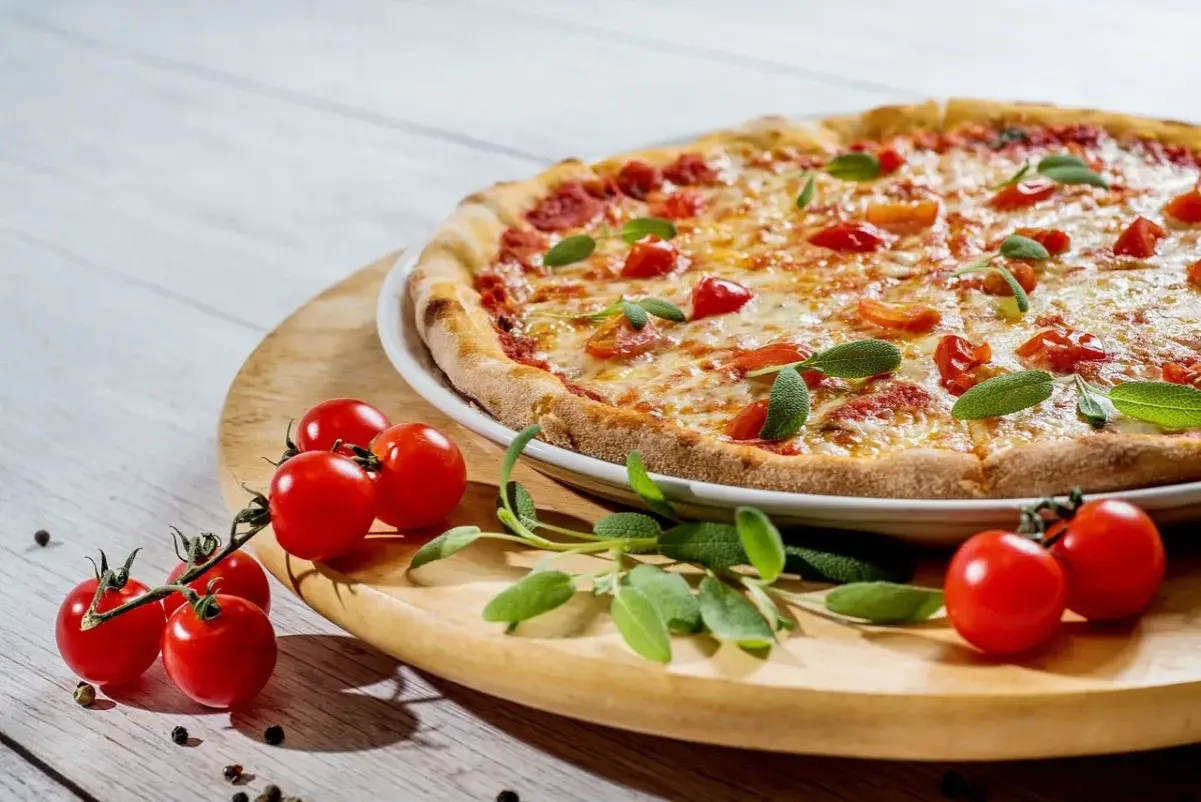 Pyszne ciasto na pizzę z jajkiem, pomidorkami i bazylią, gotowe do podania.