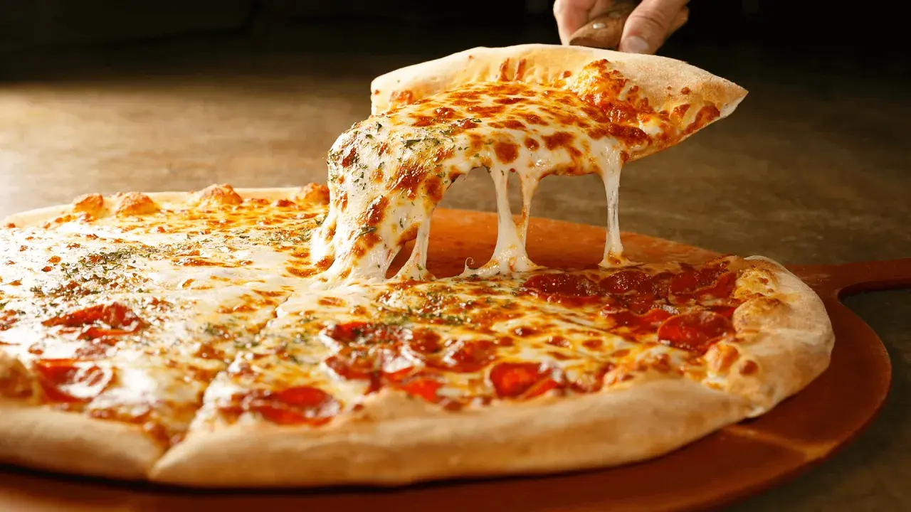Rozciągający się ser z domowej pizzy z pepperoni i ziołami. Idealne składniki na pizzę domową.