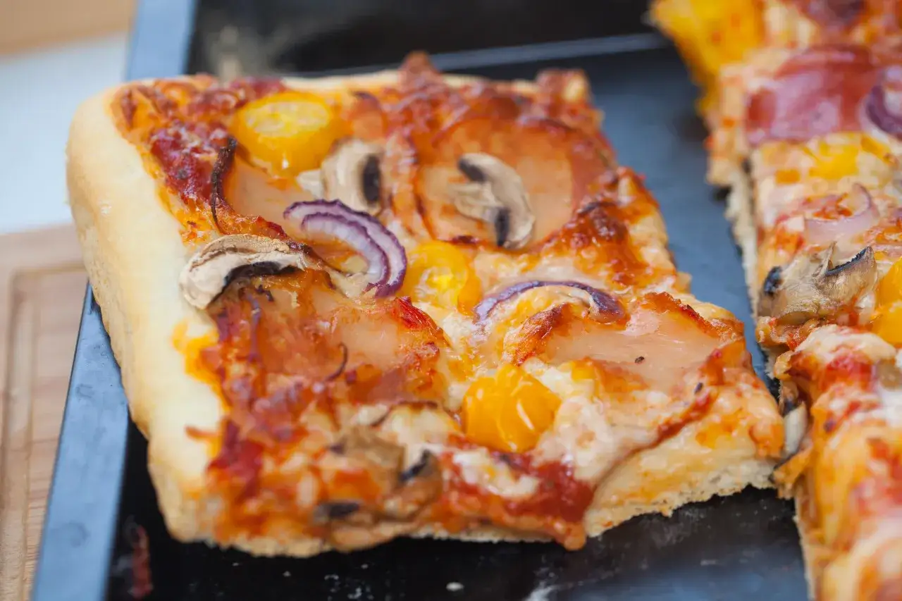 Puszyste ciasto pizzy z pieczarkami, cebulą i żółtymi pomidorkami. Idealna na letni wieczór.