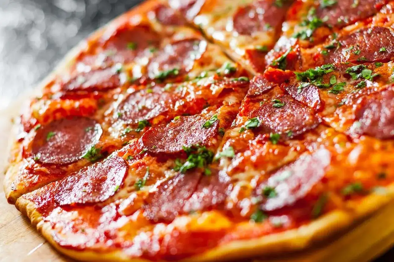 Pyszna pizza bez drożdży z pikantnym salami i posypką z ziół, idealna na szybki obiad.