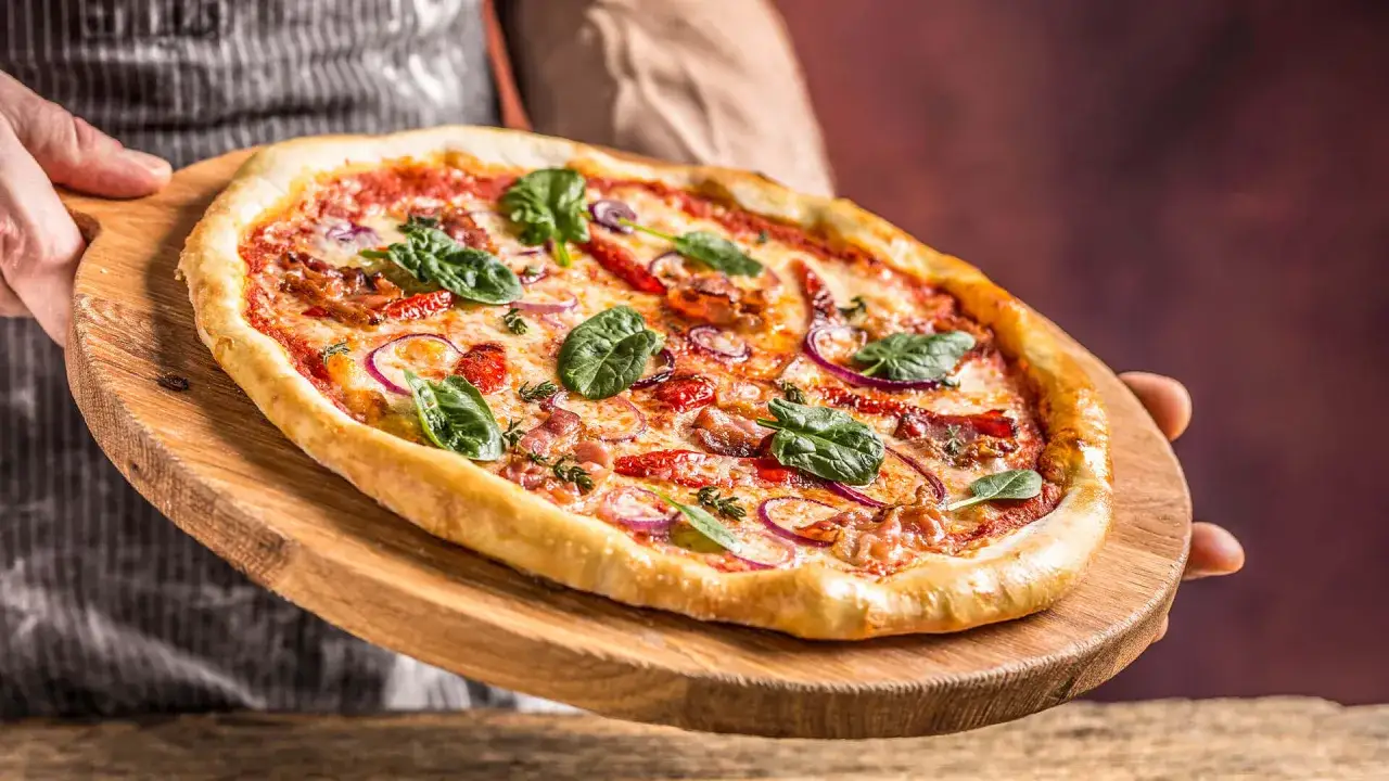 Apetyczna pizza z szpinakiem i cebulą. Czy pizza jest ciężkostrawna? Zależy od składników, ale ta wygląda lekko i pysznie!