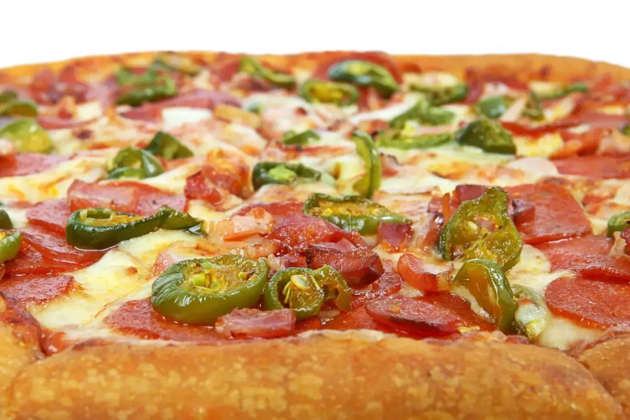 Pyszna pizza wiejska z pikantnymi papryczkami jalapeno, salami i serem. Idealne pizza wiejska składniki dla miłośników ostrych smaków.