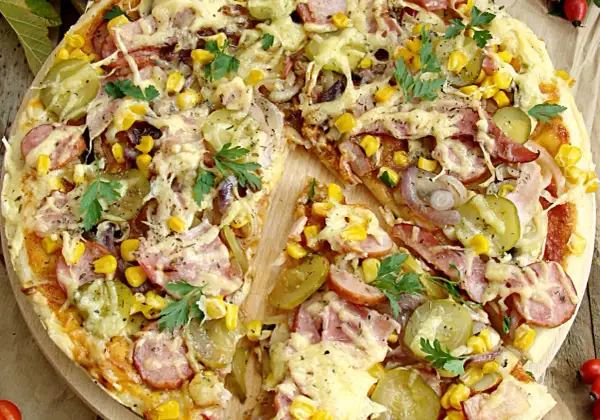 Pizza wiejska składniki: ser, kukurydza, ogórek kiszony, cebula, kiełbasa, szynka, natka pietruszki. Apetyczny widok!